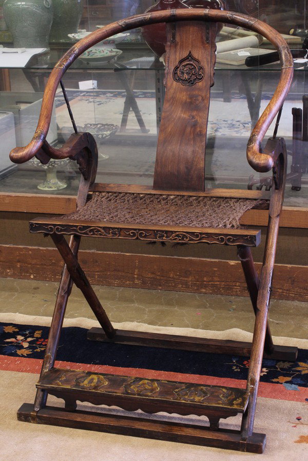 Chinese Mixed Wood Folding Chair: Chinese carved mixed wood folding chair, with a contoured back splat carved with a writhing dragon in a sunken reserve all joined to the horse shoe form back rail and the back of the woven seat, all r