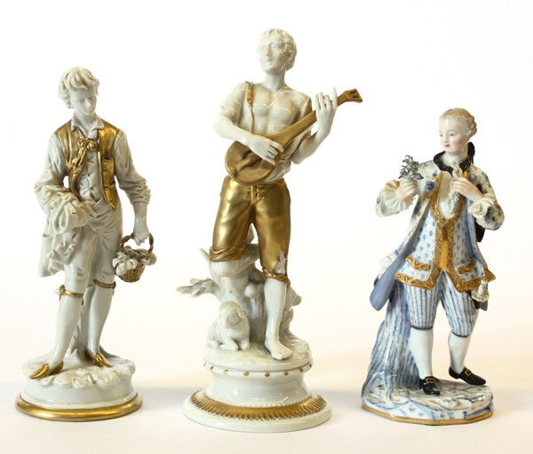 Group of three porcelain figures: (lot of 3) Continental porcelain figurines consisting of a Meissen Nobleman in Baroque attire in blue and white decoration with gilt accents, with blue crossed sword mark to the underside; together wi