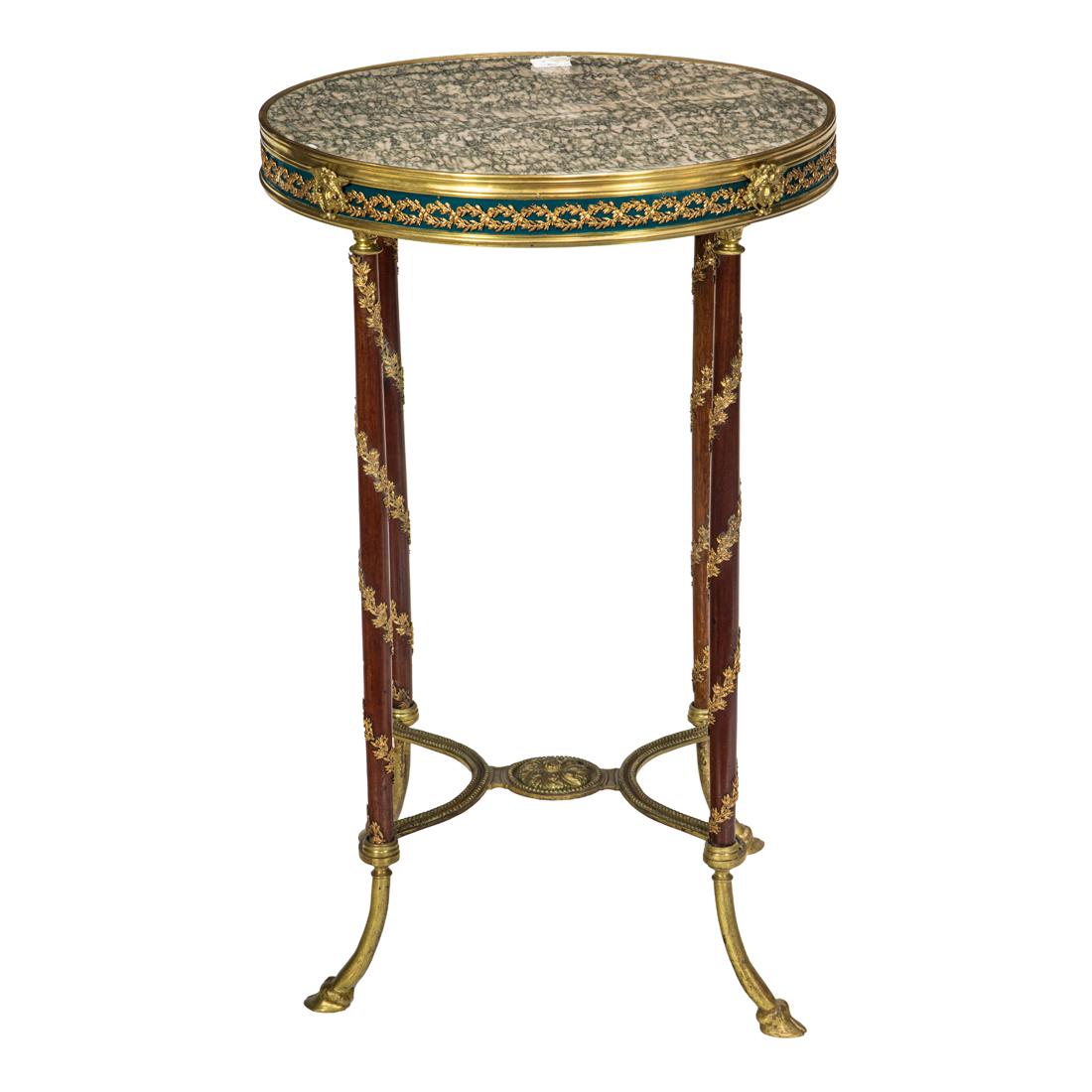 A Directoire style gilt bronze mounted mahogany and marble gueridon: A Directoire style gilt bronze mounted mahogany and marble gueridon, early 20th century the round top with galleried frieze rising on four legs ending in hoofed feet, joined by stretcher centering a r