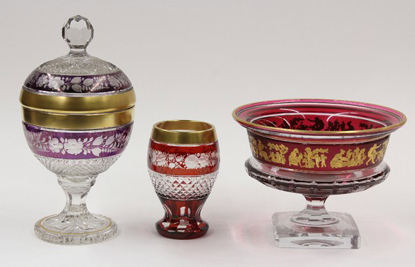 Val St Lambert footed bowl: (lot of 3) Group of etched cranberry crystal, comprising a covered compote having a bulbous body continuing to the faceted circular base, 12''h; a vasiform shaped tumbler having a floral frieze, 6.5''