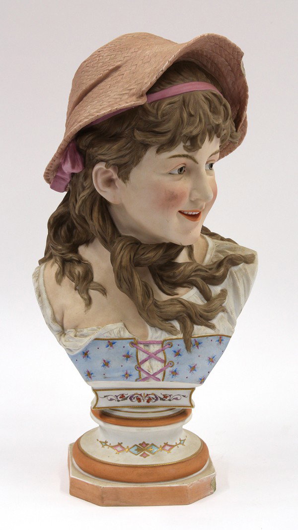 Ceramic bust of a girl: Ceramic bust of a girl, having a joyful facial expression and modeled in rural attire wearing a straw hat and a blue dress decorated with wildflowers, rising on a graduated circular plinth, marked R.