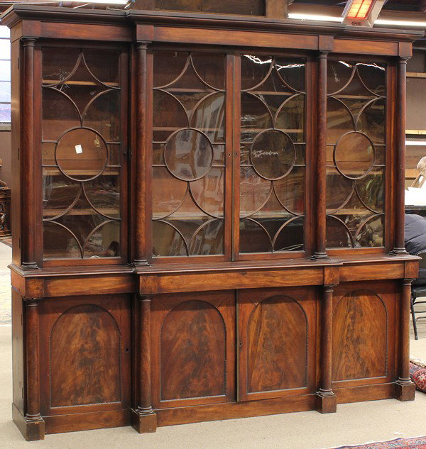 William IV figured mahogany breakfront: William IV figured mahogany breakfront circa 1820, the moulded cornice above the four door superstructure retaining the original glazed mullioned panels centered with full turned columnar pilasters, t