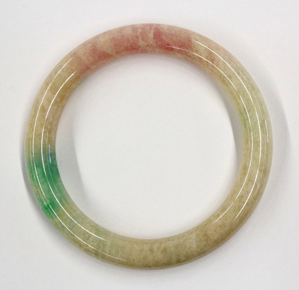 Chinese Jade/Jadeite Bracelet: Chinese jade/jadeite bangle bracelet, the crystalline buff colored matrix brightened with splashes of green and pink, overall: 3.25''