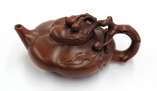 Chinese Yixing Teapot, Peach: Chinese Yixing zisha ceramic teapot, in the form of a compressed peach with a branch handle and a fitted lid applied with two small peaches, the base marked 'Wang Yinxian', 6.5''w
