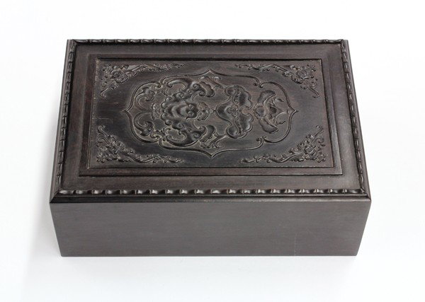 Chinese Hardwood Box: Chinese dark hardwood box, of rectangular form with a sliding lid decorated with a bat suspending a ruyi plaque above a blossom, the corners further accented with bats and scrolling tendrils, 6.4''