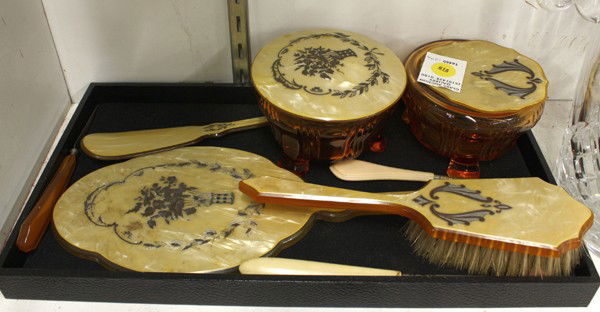 American woman's grooming set: American woman's celluloid and glass grooming set consisting of two glass bowls having an engraved lid, a hand mirror, a brush and manicure items, marked Dupont Pyralin U.S.A.