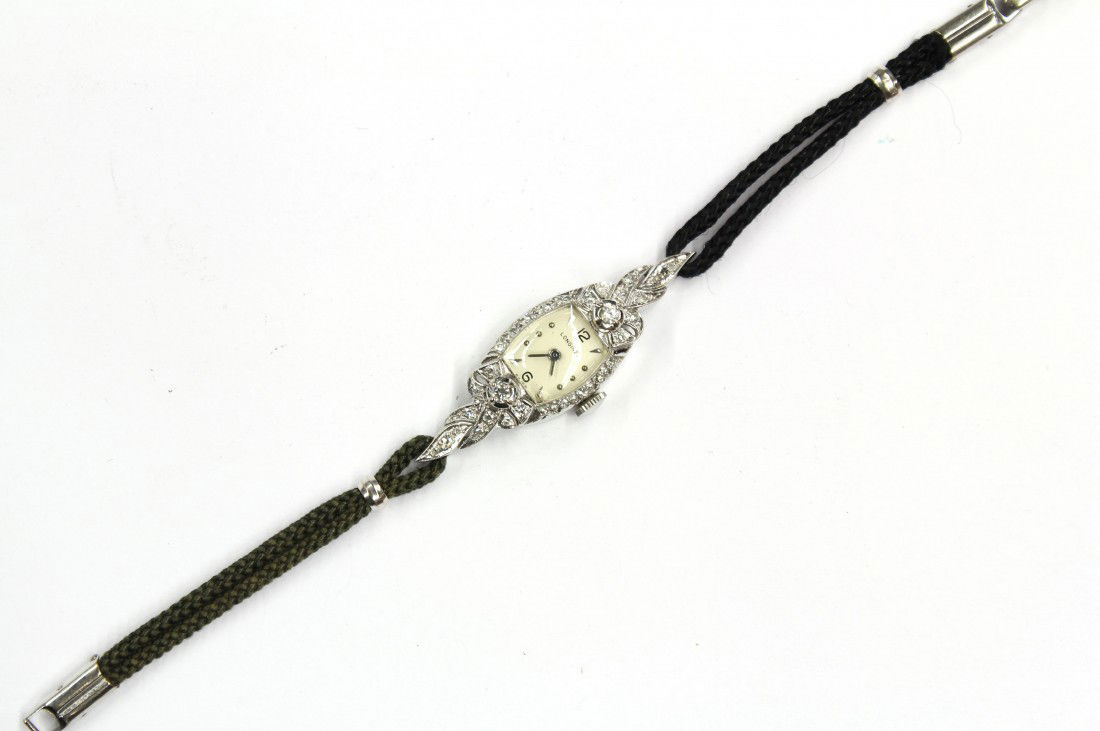 Diamond Longines white gold wristwatch: Diamond accented Longines wristwatch; in 14k white gold, set with (2) round full cut and (26) round single cut diamonds, weighing in total approximately 0.26 ct, having 17 jewel movement, black cord b