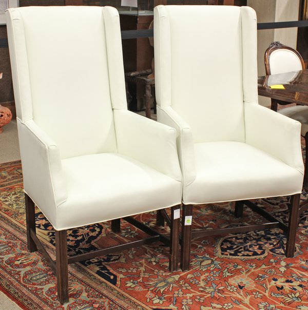 Moderne style armchairs: (lot of 2) Moderne Italian style armchairs, the stylized wing back form having white upholstery trimmed in single welt edging and rising on square incised legs conjoined by an H stretcher, 45''h x 24'