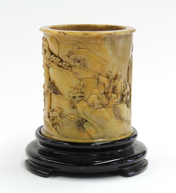 Chinese Yellow Soapstone Brush Pot: Chinese soapstone cylindrical brush pot, carved with two scholars accompanied by an attendant carrying a qin, all walking up a mountain path towards an elegant gathering with one scholar pointing at a