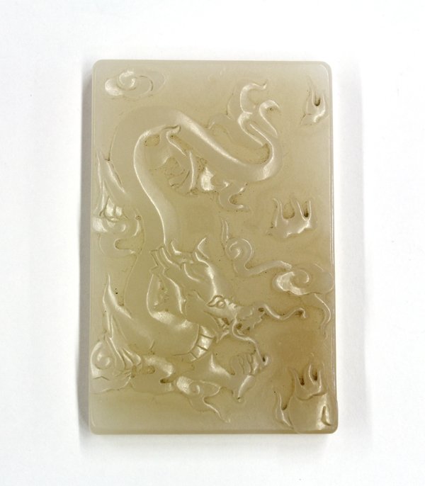 Chinese Jade 'Dragon' Plaque: Chinese jade rectangular plaque, carved with a writhing dragon in pursuit of a sacred jewel, the reverse reads 'xiang long cheng chang', the matrix of a tan-russet hue, 2.5''h