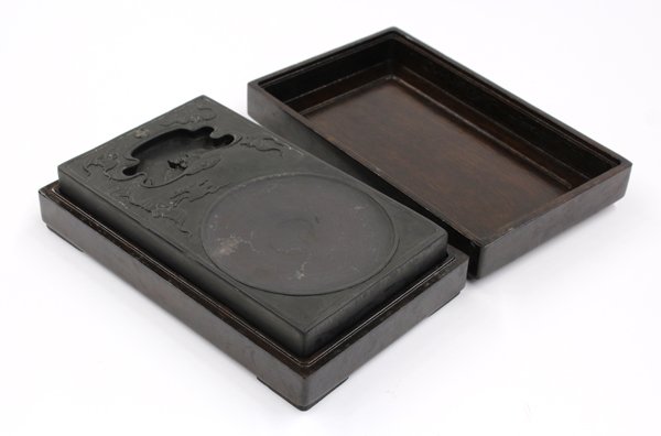 Chinese 'Bat' Ink Stone and Wood Box: Chinese carved ink stone with wooden box, the rectangular slab carved with four bats in low relief encircling a cloud-form well carved with the fifth bat to the interior, the lower section with a shal