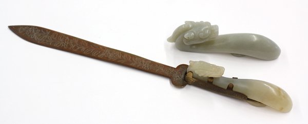 Two Chinese Jade Belt Hooks: (Lot of 2) Chinese jade belt hooks, each of pale green nephrite with a plain arching shaft reversed by a circular 'button', the smaller mounted as the handle of a letter opener and carved with a drago