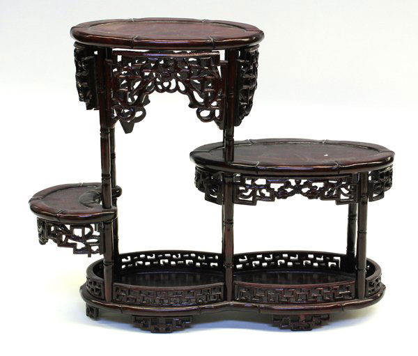 Chinese Tiered Rosewood Stand: Chinese carved and pierced rosewood stand, with one crescent and two staggered oval platforms with reticulated aprons and raised on faux bamboo supports fitted into a double-oval lower section with a