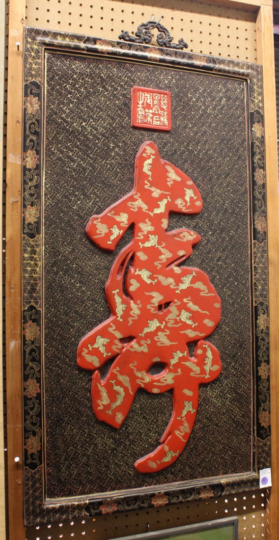 Chinese Large Lacquer Shou-Character Panel: Chinese large lacquer decorated panel, featuring a large raised red-lacquer 'shou' character painted with gilt bats and cloud scrolls and reserved on a gilt-patterned fret-work ground and set within a