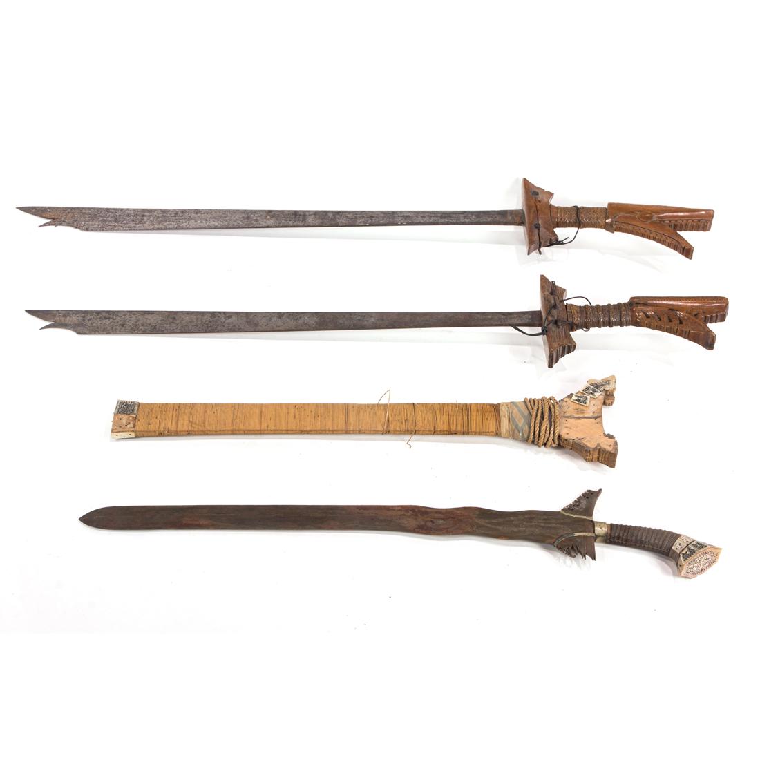 Three Southeat Asian swords, each with a carved wood hilt (1 of 2)