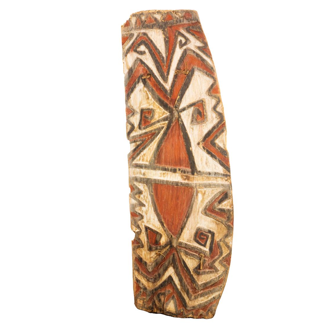 A Telefomin shield in orange and white: A Telefomin shield in orange and white, Papua New Guinea, significant signs of age and use, 5'8" x 24"w Provenance: Collection of Vanna and N. Lee Lacy (Palm Springs, California). Mr. Lacy was a promi