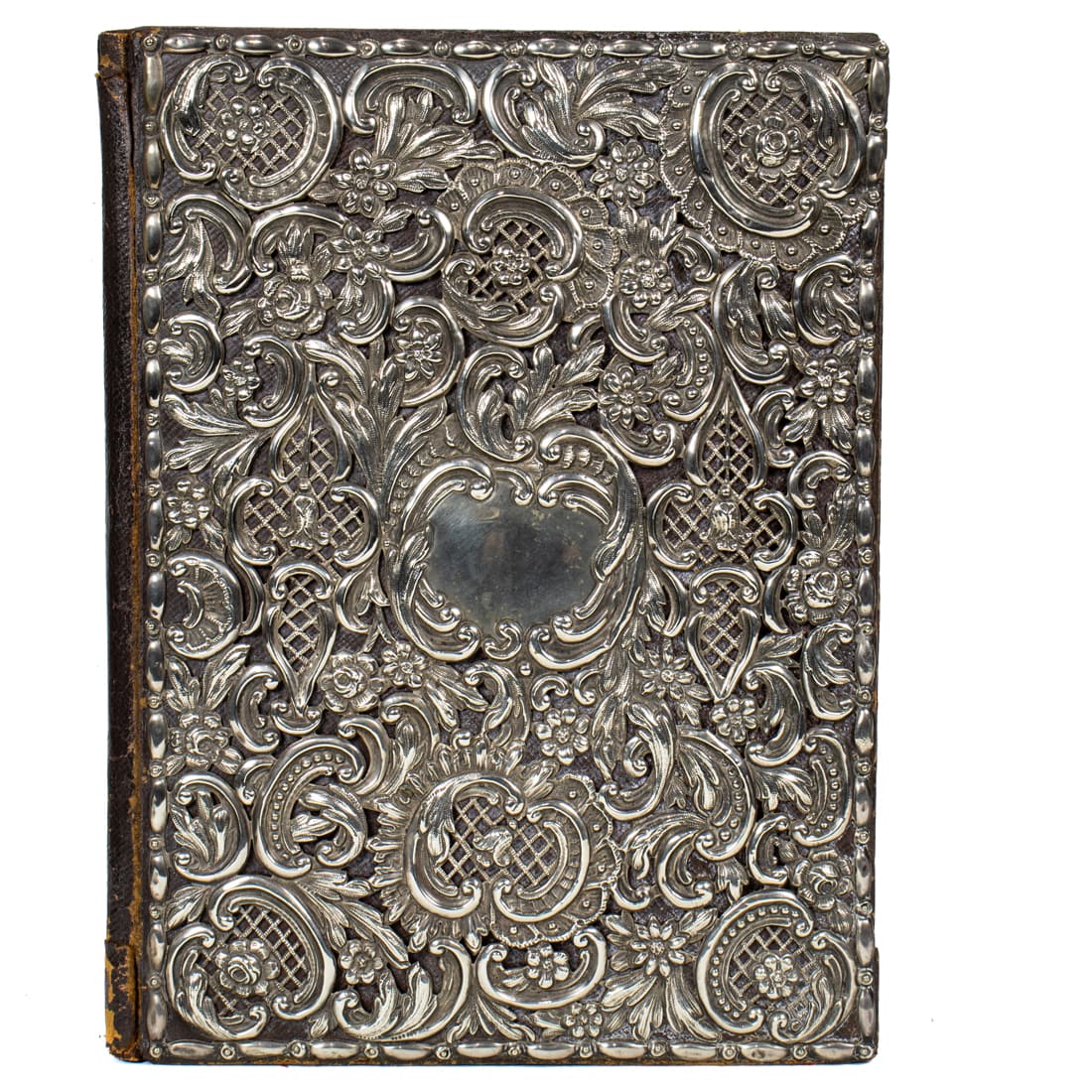 Art Nouveau repousse sterling mounted book journal fashioned in the Rococo taste: Art Nouveau repousse sterling mounted book journal fashioned in the Rococo taste, the cover mount decorated allover with flowering leafy rocaille scrolls and lattice work panels, on a brown leather co