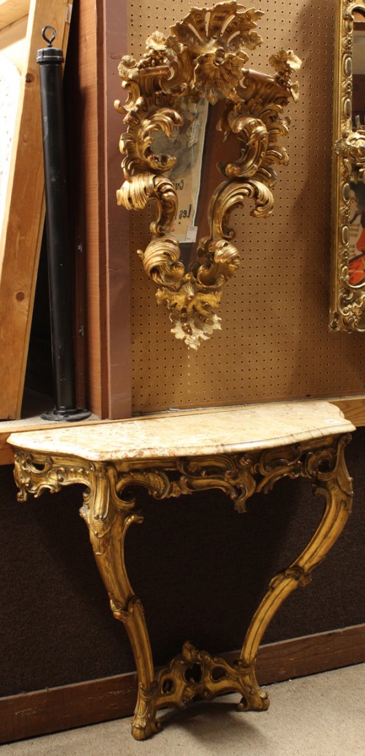 Rococo style mirrored console table: (lot of 2) Continental Rococo style mirrored console table circa 1870, the giltwood carved mirror of shield form having a high relief decorated border with scrolling detail centered with a shell form 