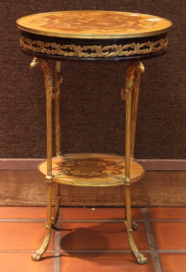 Neoclassical style inlaid gueridon: Neoclassical style inlaid gueridon, the circular top having floral and geometric marquetry reserves above the gilt bronze mounted apron rising on figural fluted supports conjoined by the lower tier an