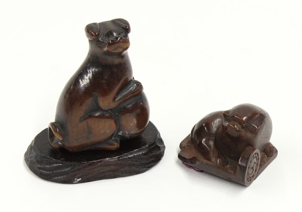 Two Japanese Boxwood Netsuke, 19th Century: (Lot of 2) Japanese boxwood netsuke, 19th century, the first of a dog seated with its front paws resting on a large ball, 1.6''; the second of a puppy resting on a roof tile, 1.25''. Provenance: Unacc