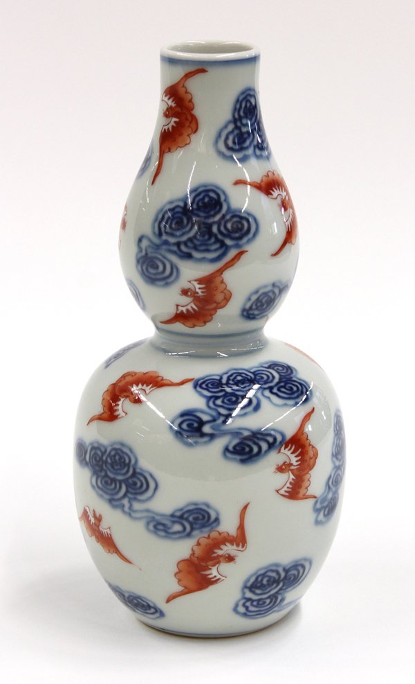 Chinese Underglaze Blue/Enamel Decorated Vase: Chinese underglaze blue and enamel decorated ovoid vase, 20th century, of double-gourd shape and decorated with red enameled bats with white accents and flying amid cobalt blue cloud scrolls, the rece