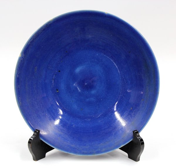 Chinese Cobalt Blue Porcelain Plate: Chinese monochrome blue glazed porcelain plate, with sloping sides encircling the shallow well, the exterior and interior coated with a cobalt blue glaze, the recessed base with a colorless glaze (min