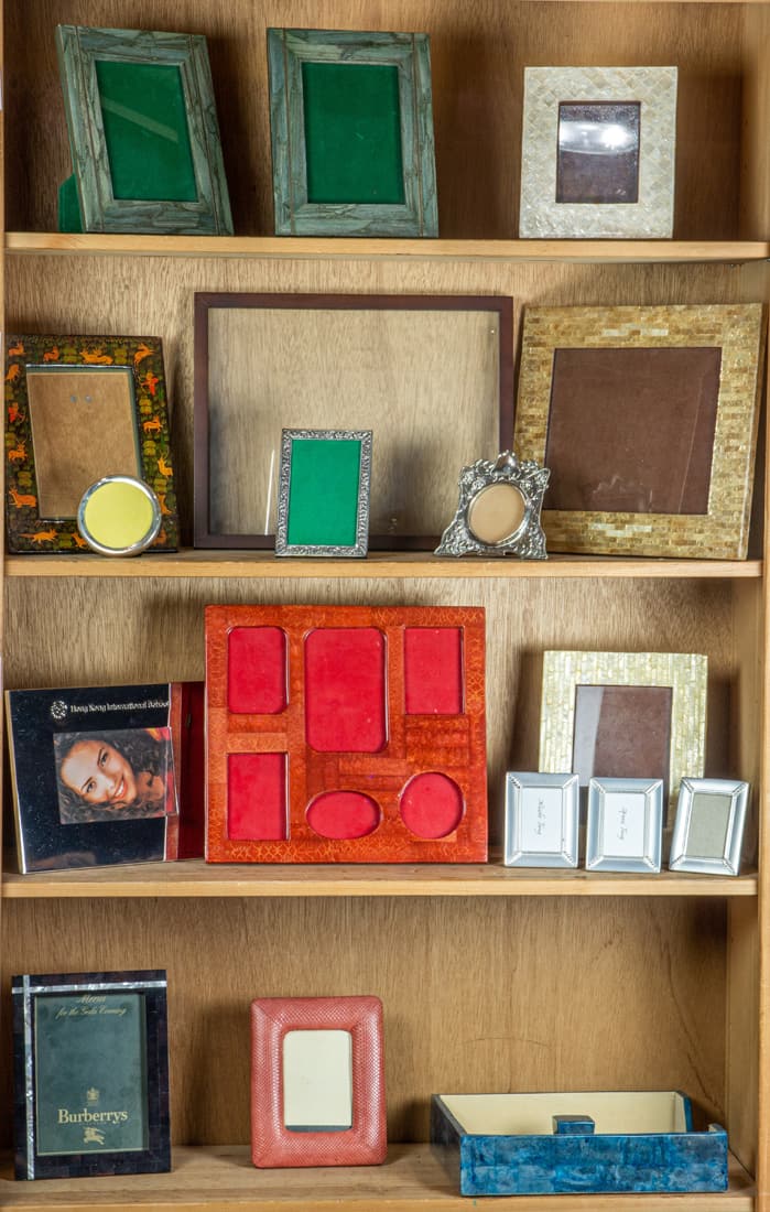 Four shelves of mostly contemporary lacquered, mother of pearl, sterling and plated picture frames,: Four shelves of mostly contemporary lacquered, mother of pearl, sterling and plated picture frames, each with easel supports