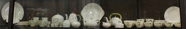 Belleek porcelain group: (lot of 38) Belleek porcelain group, each clover decorated basketweave pattern, mostly with green marks, including teapots, cups and saucers, a covered biscuit jar, egg cups, plates, etc., biscuit jar