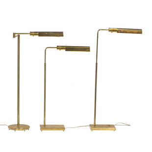 A pair of Contemporary adjustable lacquered brass reading floor lamps and another similar lamp: A pair of Contemporary adjustable lacquered brass reading floor lamps, retailer's sticker for Casella Lighting, San Francisco, adjustable 32"h to 46"h, together with a similar swing arm floor lamp [3