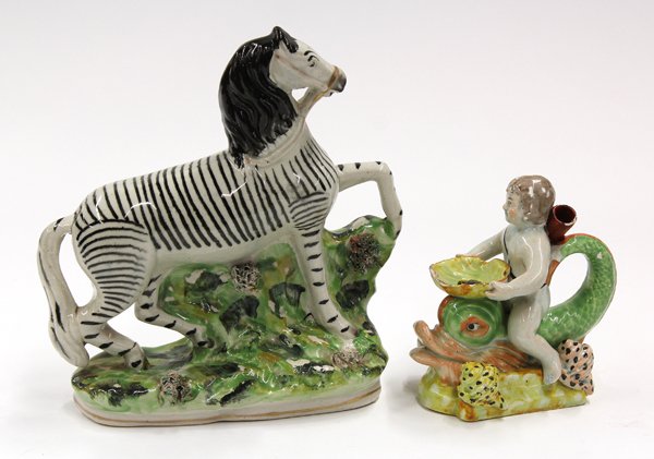 Pearlware Pottery Group: (lot of 2) Pearlware pottery group 19th century, Consisting of a polychrome decorated zebra depicted in motion and rising on a naturalistic plinth 8''h x 3.375''w (cracks), together with a single ligh
