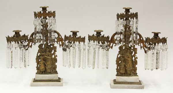 American gilt metal candelabra: Pair of American gilt metal candelabra, circa 1880, each three light fixture having lustre prisms surrounding the bobeche, rising on a scenic standard depicting a harvest scene, and mounted on cararra