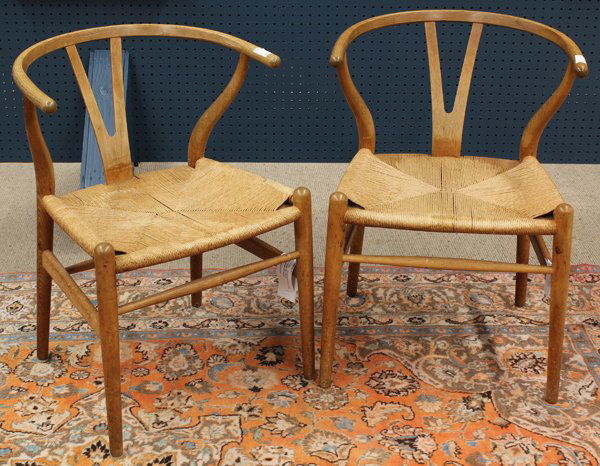Hans Wegner wishbone chairs: Pair of Hans Wegner (1914-2007) wishbone chairs, each having a continuous arm over the wishbone splat, and rising on turned legs, 28''h
