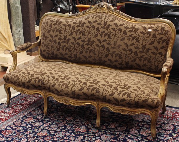 Neoclassical Style Settee: Neoclassical style giltwood carved settee, 19th century, having a serpentine floral carved crest rail, surmounting the padded back, the shaped seat of conforming serpentine form rising on cabriole leg