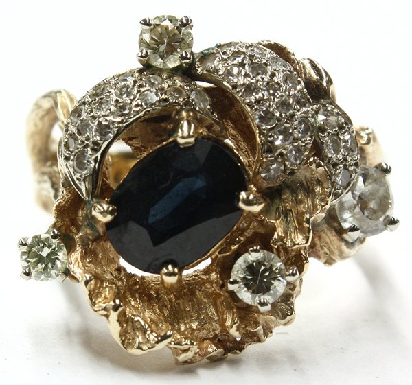 Lady's free-form sapphire diamond ring: Lady's free-form style sapphire and diamond ring; mounted in yellow gold (stamped ''14K''), featuring (1) oval mixed cut natural sapphire, weighing 1.86 cts, accented with (39) Old Mine, round single 