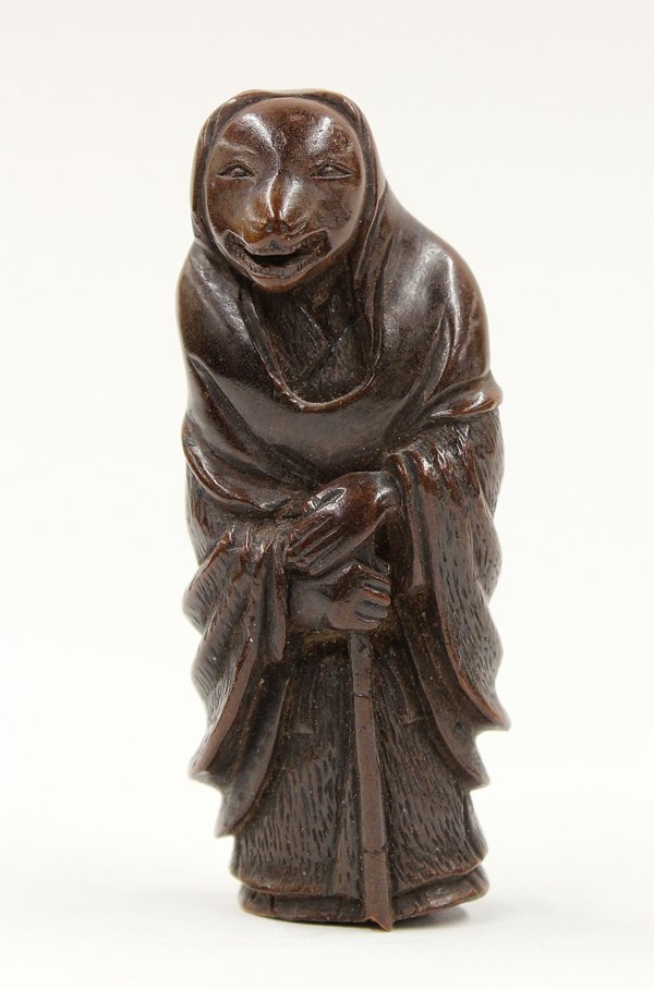 Japanese Boxwood Netsuke, Fox Priest, Edo: Japanese boxwood figural netsuke, Edo period, 19th century, depicting the Fox-Priest of legend, the anthropomorphic figure standing in the robes of a traveling monk but with the face of a fox, his han