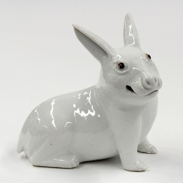 Asian Porcelain Figuirine of a Rabbit: Asian zoomorph porcelain figurine, early 20th century, of a white rabbit seated on its haunches, the turned head brightened with pigment accented alert eyes and pointed ears (hairline cracks and small