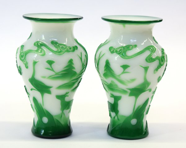 Chinese Peking Glass Vases: Pair of Chinese green overlaid white Peking glass vases, featuring a scene of deer walking toward a crane perched on a rock, 6.3''h