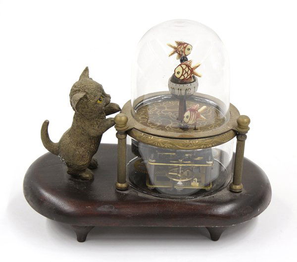 Clock group: A patinated metal cat clock automaton, having an exposed movement and rising on an oval base, 6''h