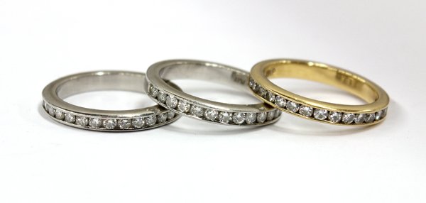 Collection of three diamond stack band rings: Three stackable diamond band rings; two in platinum and one in 18k yellow gold. Each ring is set with (16) round full cut diamonds. Having a combined total of (48) round full cut diamonds, having a co