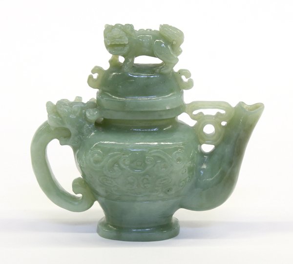 Chinese Hardstone Ewer: Chinese green hardstone ewer, the tapering body carved with taotie masks, all flanked by a long spout and a handle issuing from the jaws of a zoomorph, together with a lid fashioned with a fu-lion, al