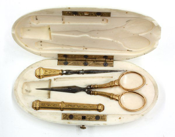 French ivory sewing kit: 19th century French ivory sewing case, the fitted interior with scissors, bodkin and needle holder, the exterior having a scrimshaw script monogram (minor losses)