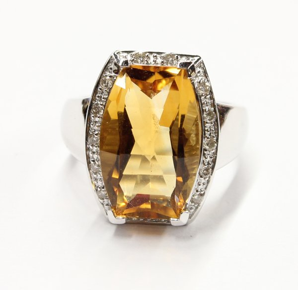 14K white gold citrine and diamond ring: Lady's citrine and diamond ring; mounted in white gold (stamped ''14K'', ''585''), center set with (1) cushion shape bar cut natural citrine and accented with (14) full cut round diamonds weighing a t