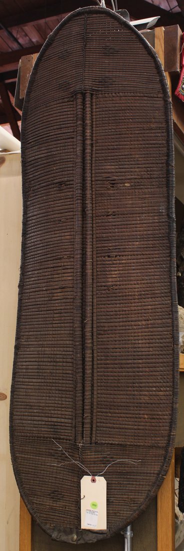 Woven Shield, D.R. Congo or possibly Uganda: D.R. Congo or possibly Uganda, woven shield, with original patina on wooden handle, having native repair of metal at bottom, 56''h x 18''w. Provenance: The Hemphill Collection of San Francisco