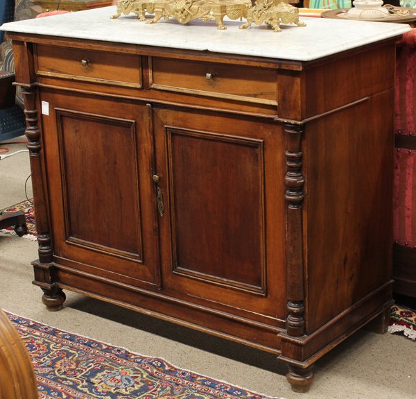 Continental walnut buffet: Continental walnut buffet circa 1860, the carerra marble top above a walnut case having columnar pilasters centering the double doors and rising on ball feet, 41''h x 48''w x 24''d