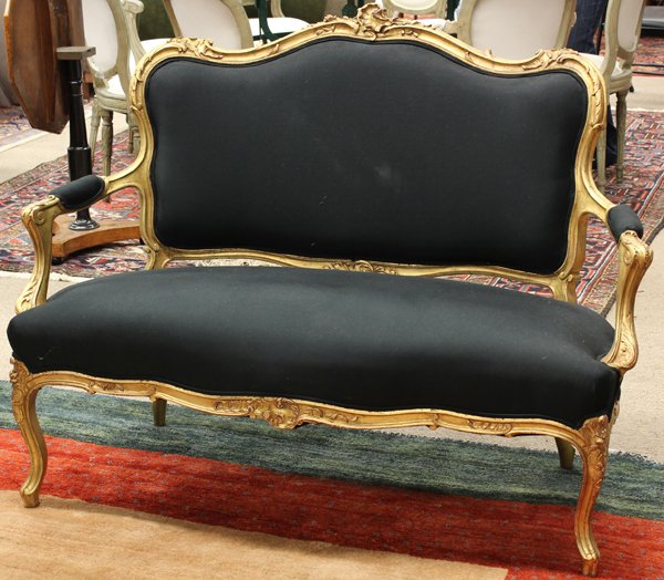 Rococo style giltwood settee: French Rococo style giltwood carved settee, having a serpentine crest centered with a rocaille medallion, the outswept arms with acanthus carved returns and rising on cabriole legs, 38.5''h x 51''w