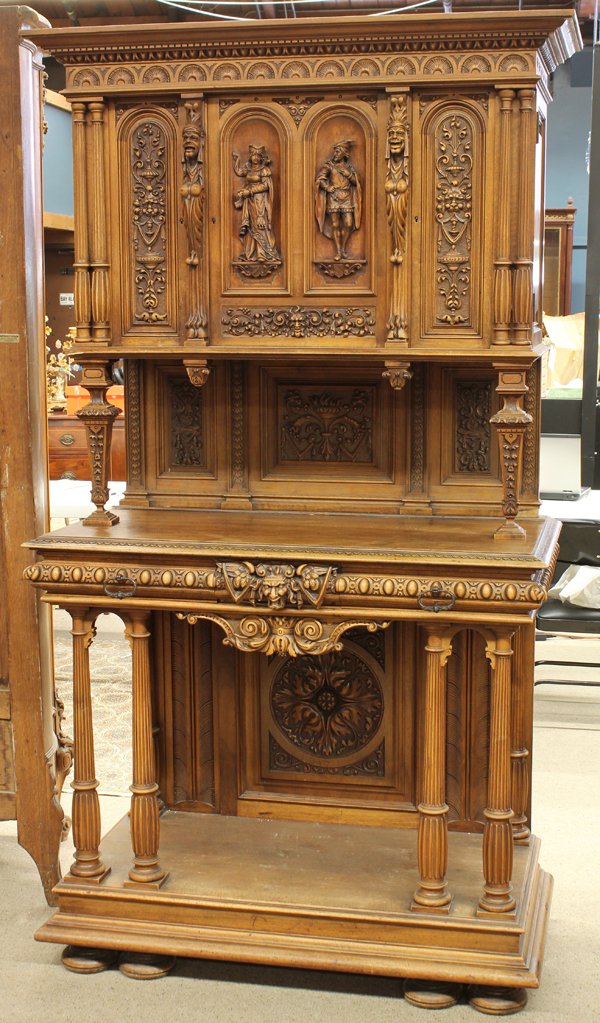 Continental carved buffet: Continental carved buffet circa 1900, the panelled super structure having full relief carved figural reserves flanked with urn and floral reserves, the two drawer lower case having a winged griffin me