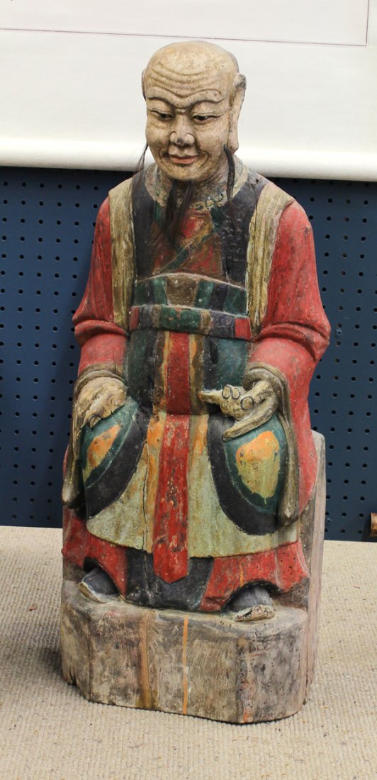 Chinese Polychrome Wood Figure: Chinese polychrome decorated large wood figure, Qing dynasty, the seated male celestial official in cascading robes of red, green, blue and buff hues, the well defined face accented with hair, all sup