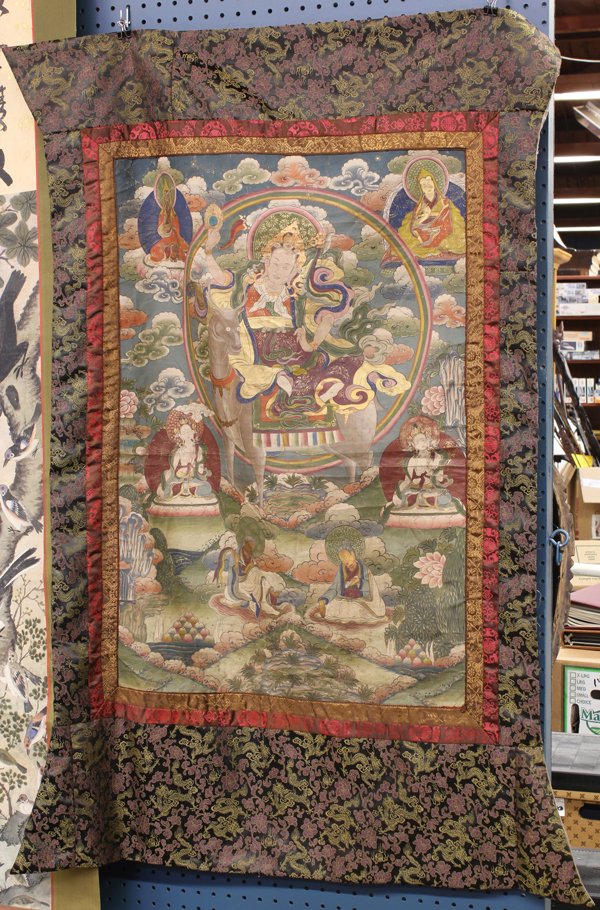 Himalayan/Tibetan Thangka: Himalayan/Tibetan painted thangka, the central panel depicting a Buddhist diety surmounted on a deer, accented by bodhisattva and teachers, 49.6''h x 30.5''w; Provenance: The Hemphill Collection of Sa