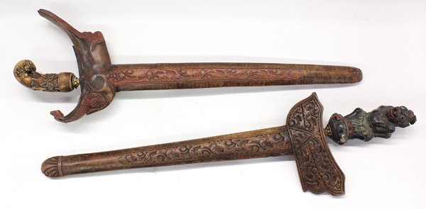 Indonesia, ''Keris'' Short Swords: (lot of 2) Indonesia, two ''Keris'' short swords, worn on men's belts, with carved wood scabbards, both with old zig-zag blades of meteoritic iron, damascened; handles are well carved one of painted w