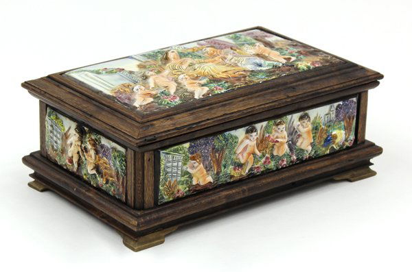 Capodimante jewelry box: Capodimonte jewelry box, the footed wood box having polychrome decorated porcelan reserves depicting playful putti in a naturalistic setting, having a hinged top opening to the mirrored and velvet lin